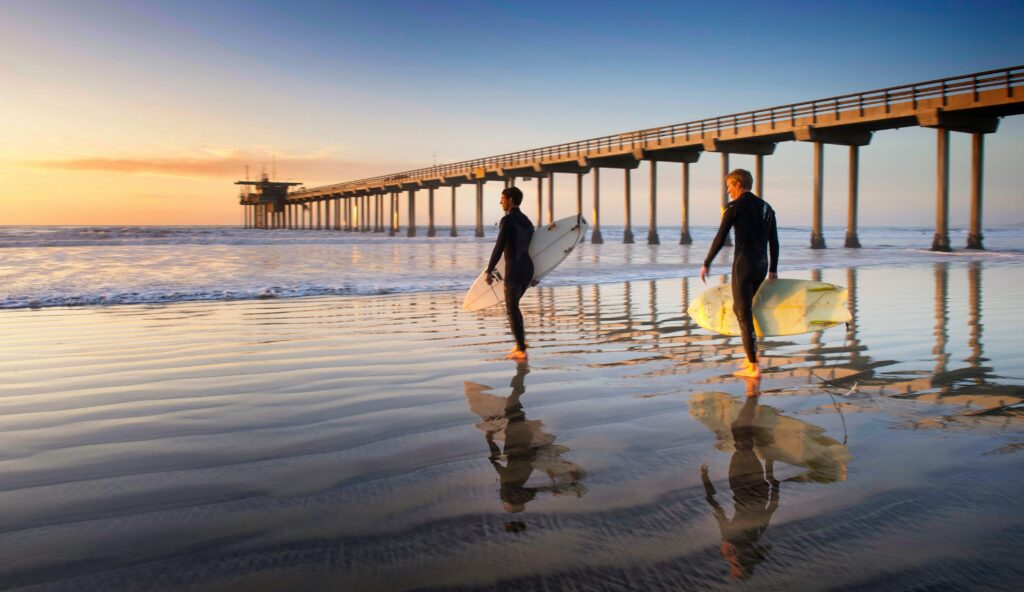 two surfers heading out at san diego beach